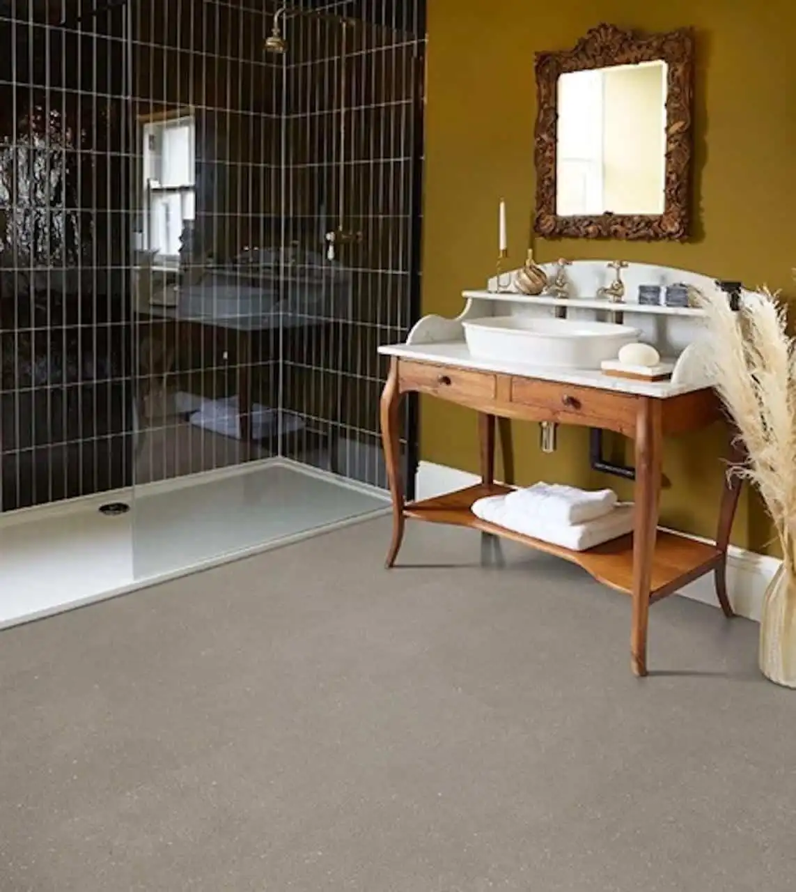 Durable LVT Flooring for Eclectic Bathrooms with Antique Vanities Light grey speckled LVT flooring in an eclectic bathroom with a wooden antique vanity, ornate mirror, and dark tiled walk-in shower.