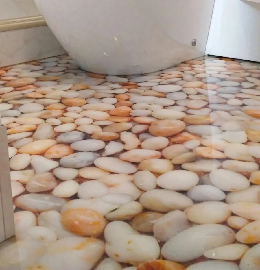 Stunning 3D Pebble Effect Epoxy Floor for Bespoke Bathroom Design Close-up of a high-gloss 3D epoxy bathroom floor featuring a photorealistic stone and pebble illusion design around the base of a white toilet.