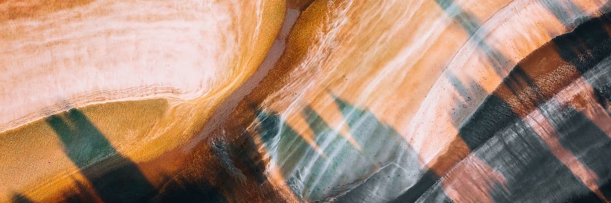 Abstract metallic resin flooring design featuring multi-toned copper, gold, and grey marble-effect swirls